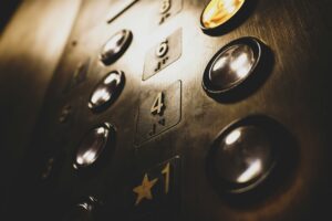 inside of an elevator with floor buttons on a metal panel